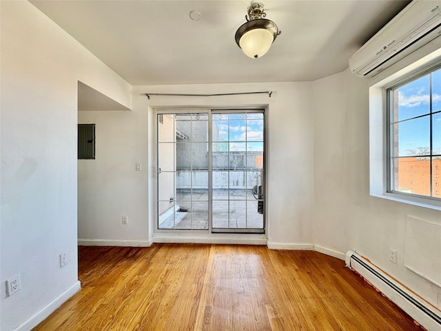 interior space featuring a wall mounted air conditioner, electric panel, light wood-style floors, a baseboard radiator, and baseboards