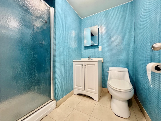 bathroom with tile patterned flooring, a shower stall, baseboards, toilet, and vanity