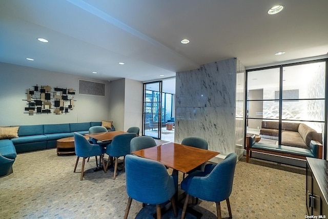 dining space with recessed lighting and a wall of windows