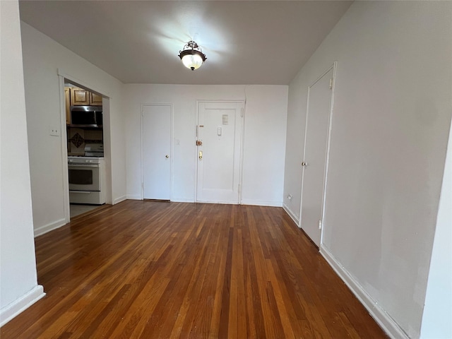 entryway with dark wood-type flooring and baseboards