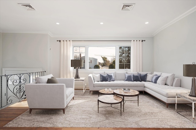 living area featuring visible vents, ornamental molding, and wood finished floors