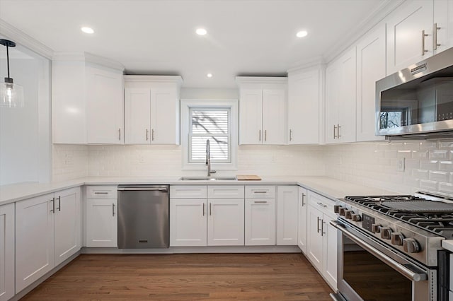 kitchen with wood finished floors, a sink, light countertops, white cabinets, and appliances with stainless steel finishes