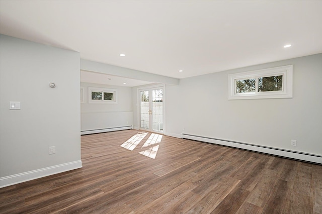 unfurnished room with wood finished floors, baseboards, a baseboard radiator, french doors, and a baseboard heating unit