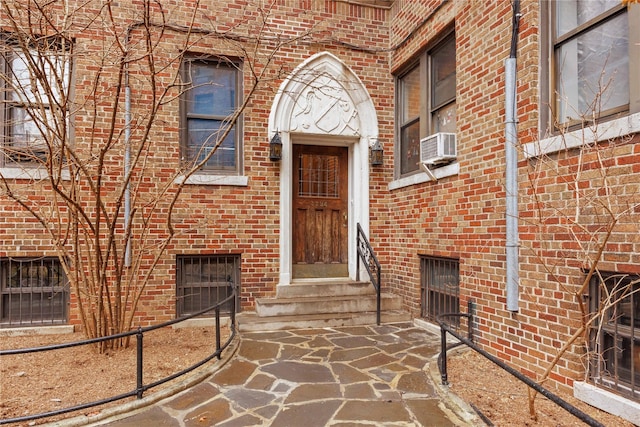 property entrance featuring cooling unit and brick siding