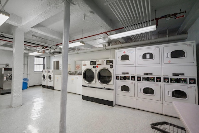 common laundry area with washing machine and dryer, stacked washing maching and dryer, and light floors