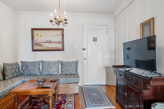 living area with a notable chandelier and wood finished floors