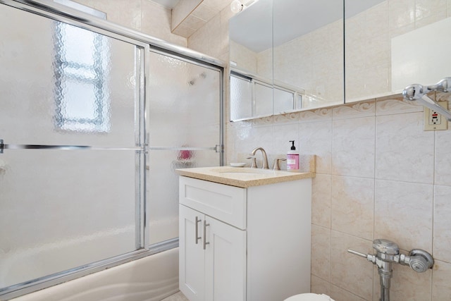 bathroom featuring enclosed tub / shower combo, tile walls, vanity, and tasteful backsplash