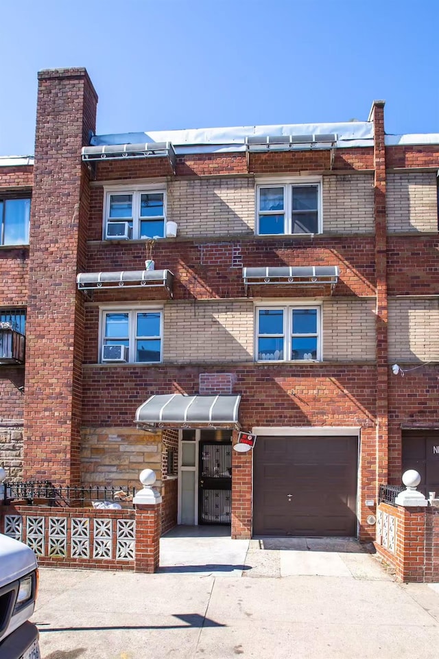 townhome / multi-family property featuring brick siding, an attached garage, and driveway