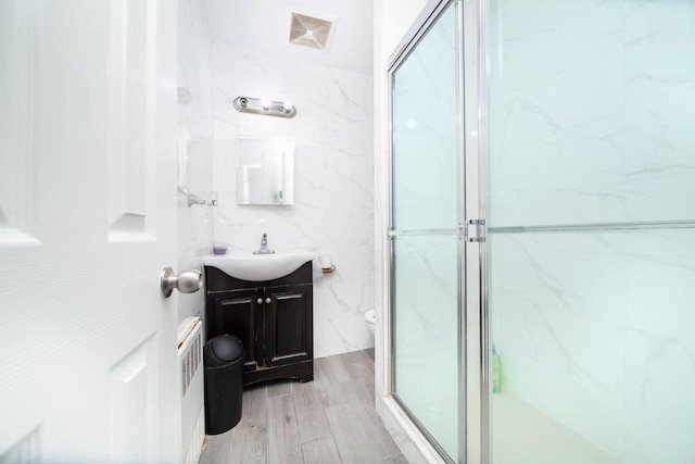 full bath with vanity, visible vents, a shower stall, tile walls, and toilet