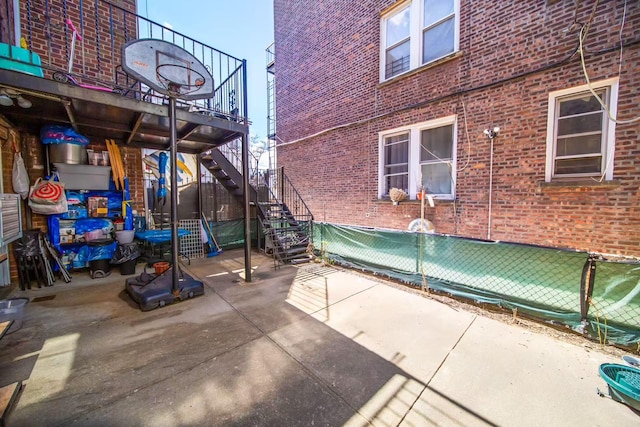 view of patio featuring stairs and fence