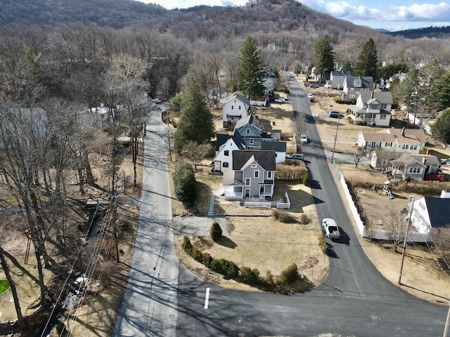 aerial view with a residential view, a mountain view, and a view of trees