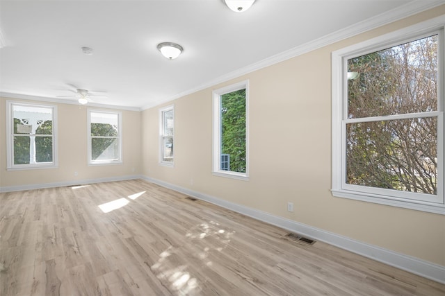 unfurnished room featuring visible vents, light wood-style floors, baseboards, and ornamental molding