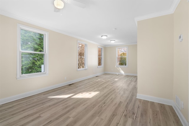 spare room with visible vents, baseboards, light wood finished floors, ceiling fan, and ornamental molding