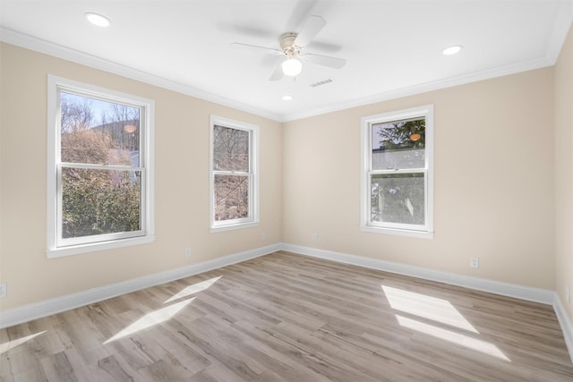 spare room with visible vents, crown molding, light wood-type flooring, and baseboards