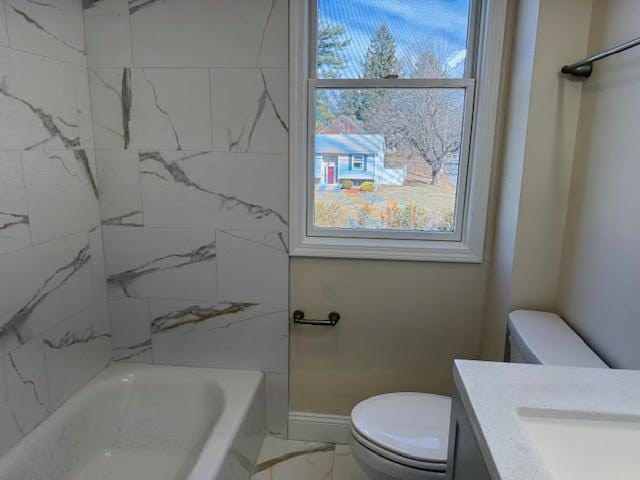 bathroom featuring toilet, marble finish floor,  shower combination, baseboards, and vanity