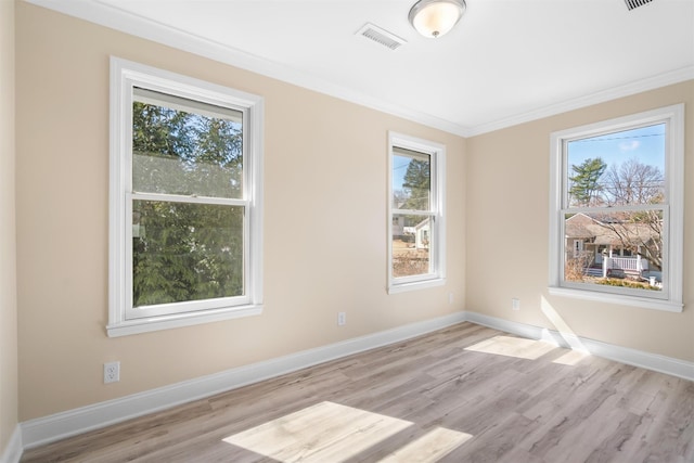 unfurnished room with visible vents, crown molding, baseboards, and wood finished floors