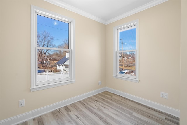 empty room featuring baseboards, plenty of natural light, light wood-style flooring, and ornamental molding