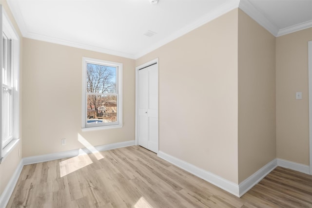 unfurnished room with baseboards, wood finished floors, and crown molding