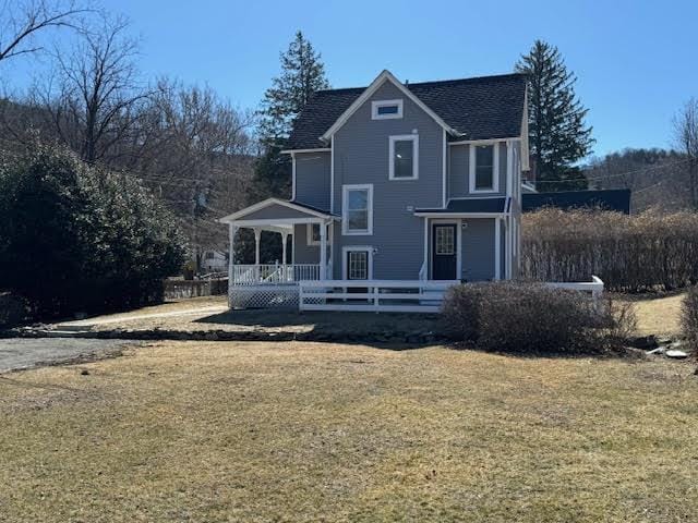 rear view of house featuring a lawn