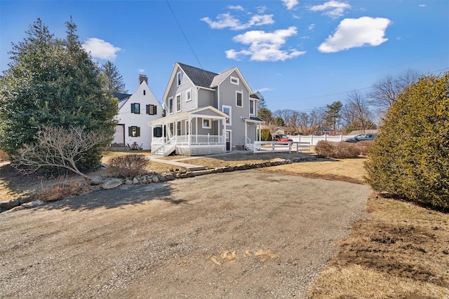 back of property with a porch and fence