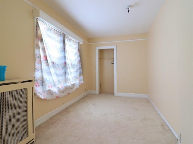 unfurnished bedroom featuring carpet flooring, heating unit, baseboards, and a closet