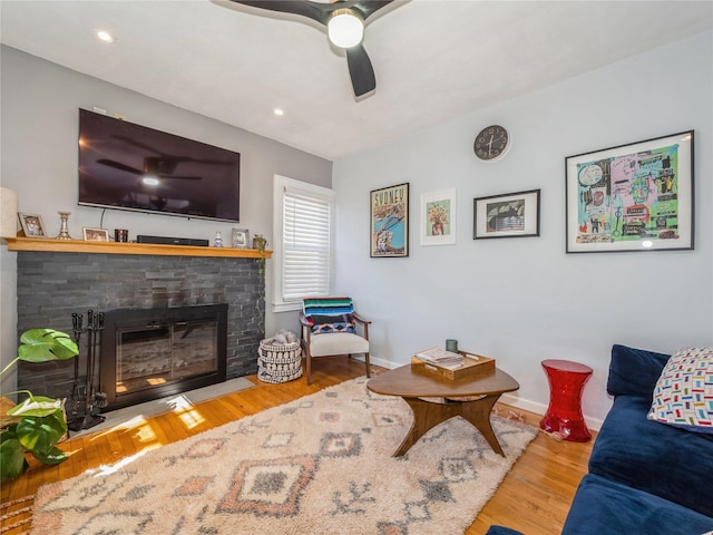 living room featuring a ceiling fan, wood finished floors, baseboards, a fireplace with flush hearth, and recessed lighting