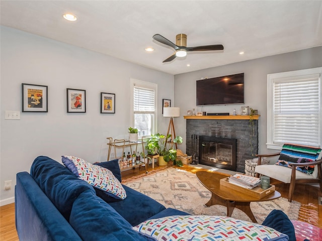 living area with recessed lighting, a fireplace, a ceiling fan, and wood finished floors