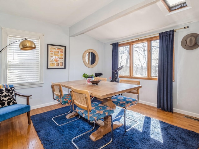 dining space with visible vents, beam ceiling, baseboards, and wood-type flooring