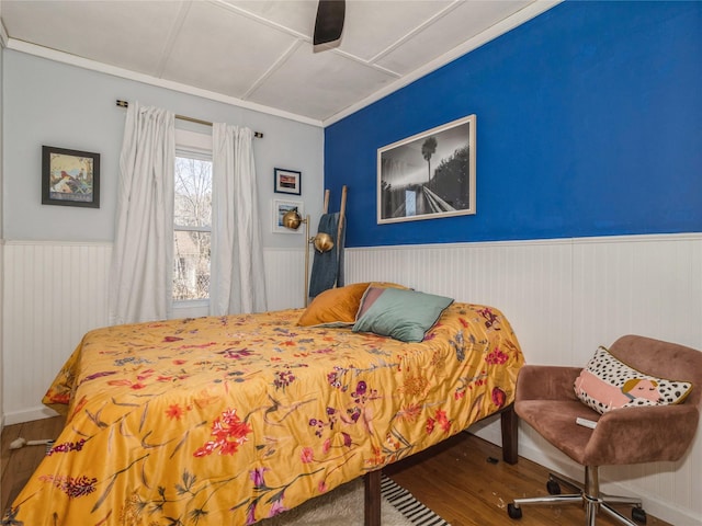 bedroom featuring wainscoting, a ceiling fan, and wood finished floors