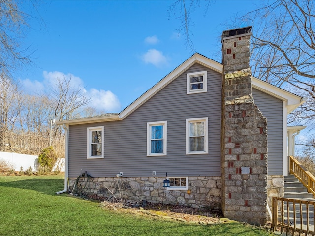 rear view of house featuring a chimney and a yard