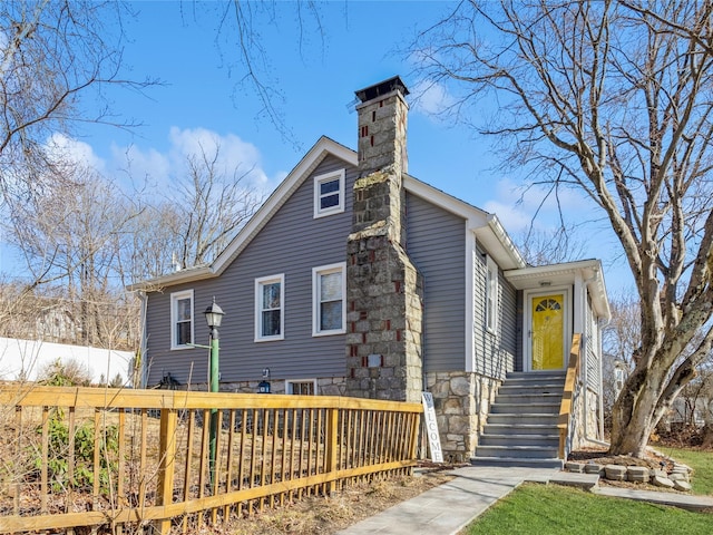 view of front facade with fence and a chimney