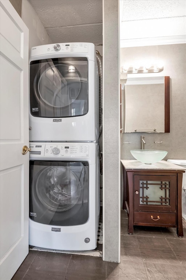 laundry room featuring a sink, laundry area, and stacked washer / dryer