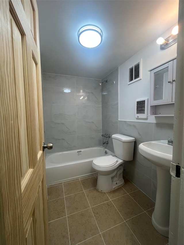 bathroom featuring visible vents, shower / bath combination, tile walls, toilet, and tile patterned floors