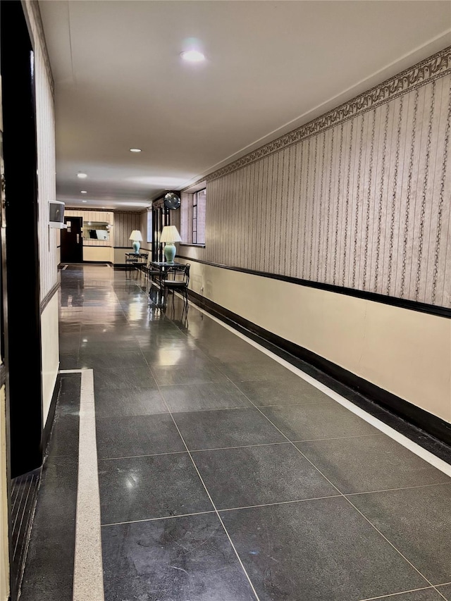 hallway with recessed lighting and baseboards