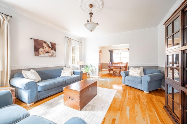 living area featuring light wood-style flooring and crown molding