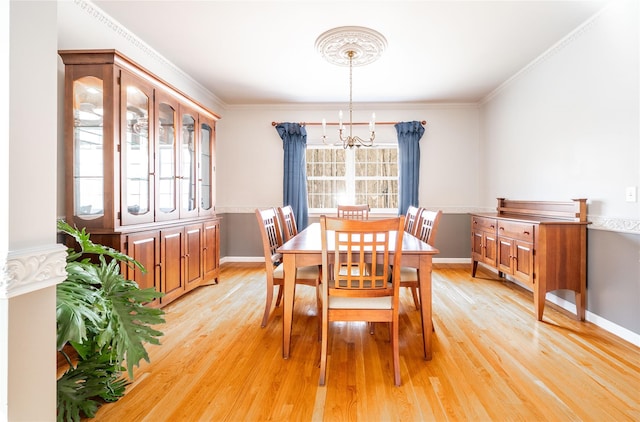 dining area featuring baseboards, light wood-style floors, and crown molding