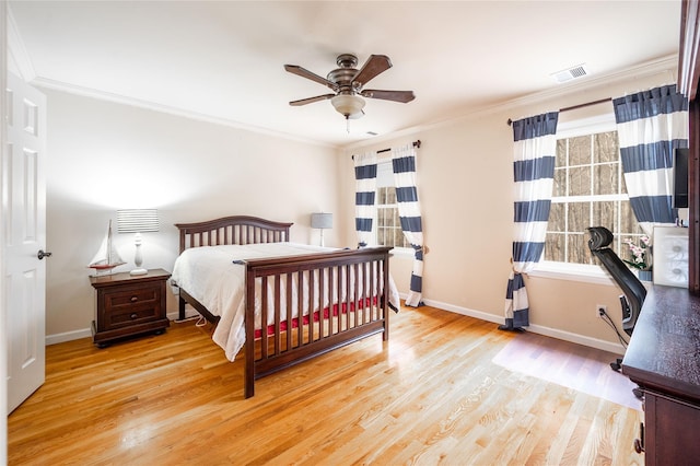 bedroom featuring a ceiling fan, wood finished floors, baseboards, visible vents, and crown molding