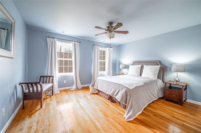 bedroom with light wood-style flooring, baseboards, visible vents, and ceiling fan