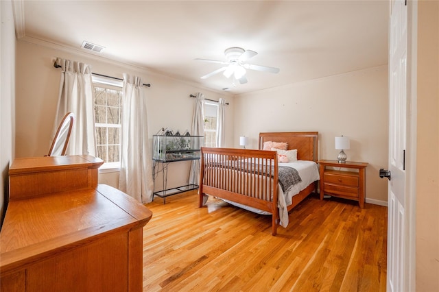 bedroom with visible vents, light wood-style floors, ceiling fan, and crown molding