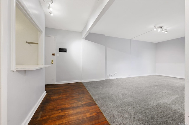 foyer entrance with track lighting, wood finished floors, and baseboards