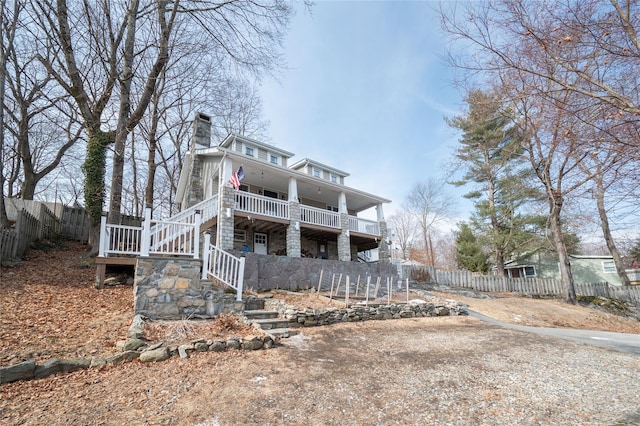 view of front of property featuring stairway, fence private yard, and a chimney