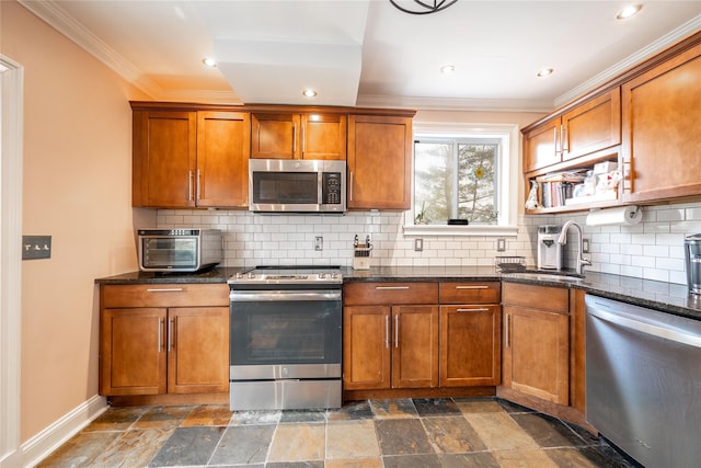 kitchen featuring a sink, stainless steel appliances, brown cabinets, and stone tile flooring