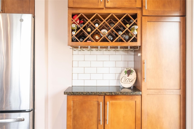 bar with decorative backsplash and freestanding refrigerator