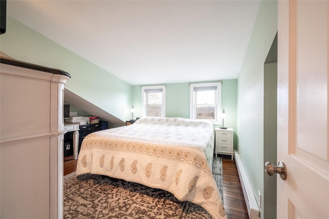 bedroom with baseboards, baseboard heating, and dark wood-style flooring