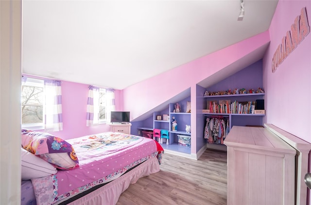 bedroom featuring lofted ceiling and wood finished floors