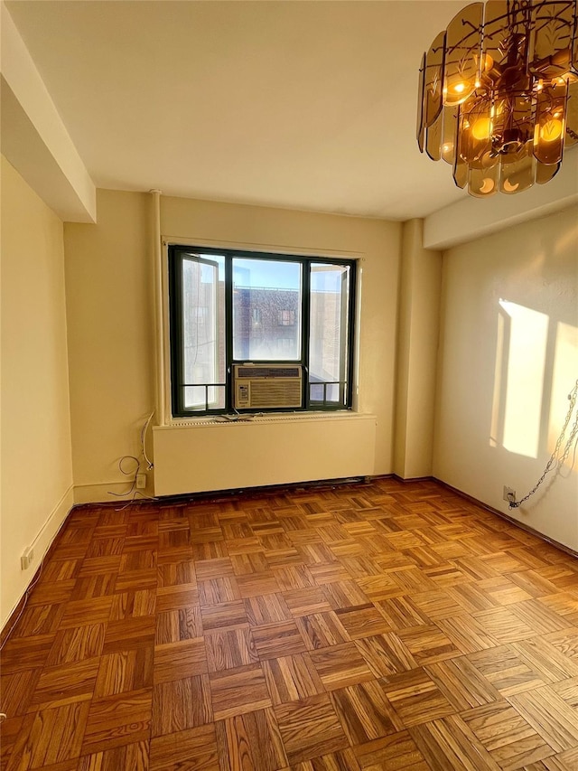 empty room with cooling unit, baseboards, and an inviting chandelier