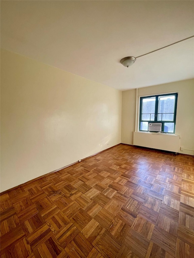 unfurnished room with cooling unit and baseboards