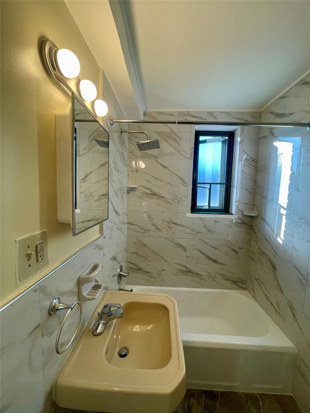 full bathroom with bathing tub / shower combination, tile walls, and a sink