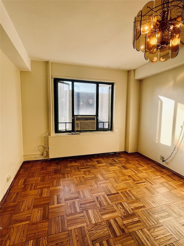 spare room featuring a chandelier, cooling unit, and baseboards