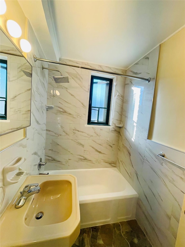 full bathroom featuring plenty of natural light, tile walls, shower / tub combination, and a sink